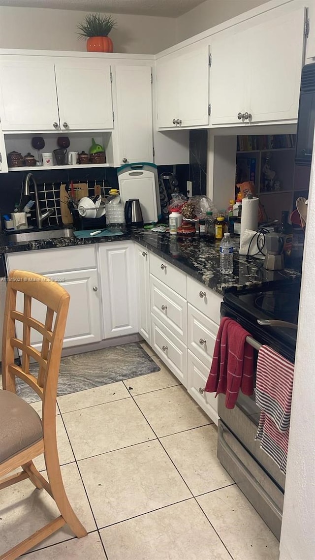 215 SE 3rd Ave Unit 106C, Hallandale Beach, FL 33009 - kitchen with stainless steel electric range oven, white cabinetry, light tile patterned floors, open shelves, and a sink
