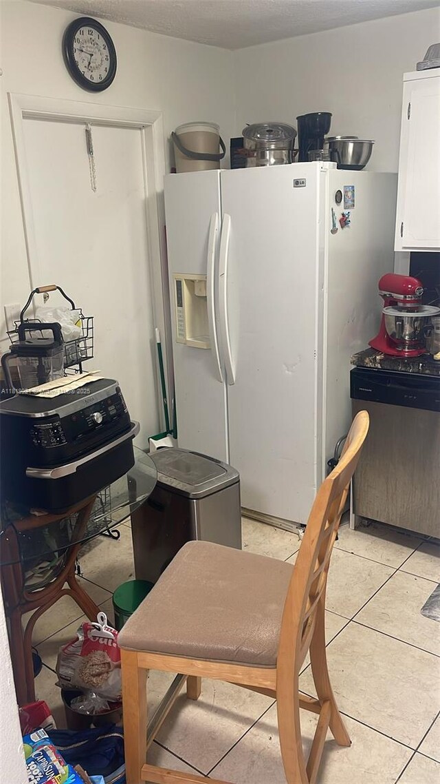 215 SE 3rd Ave Unit 106C, Hallandale Beach, FL 33009 - kitchen featuring stainless steel dishwasher, white fridge with ice dispenser, white cabinetry, and light tile patterned floors