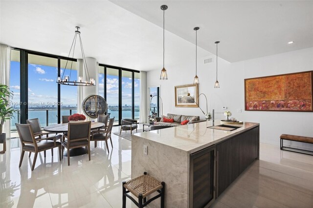 480 NE 31st St Unit Ph5303, Miami, FL 33137 - kitchen featuring floor to ceiling windows, a water view, light stone counters, light tile patterned floors, and a chandelier