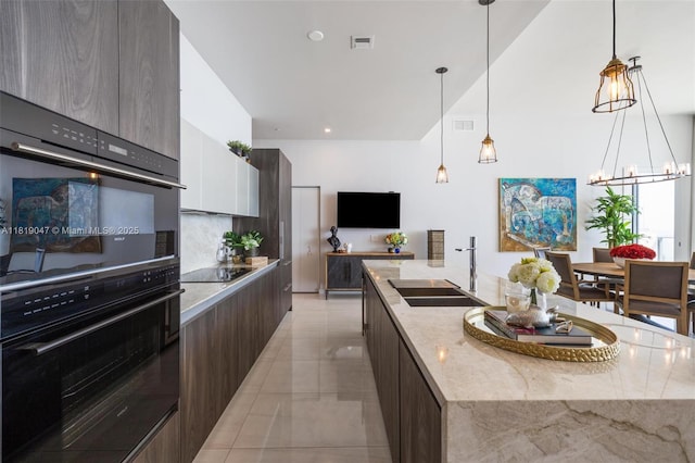 480 NE 31st St Unit Ph5303, Miami, FL 33137 - kitchen with modern cabinets, a spacious island, black appliances, and a chandelier