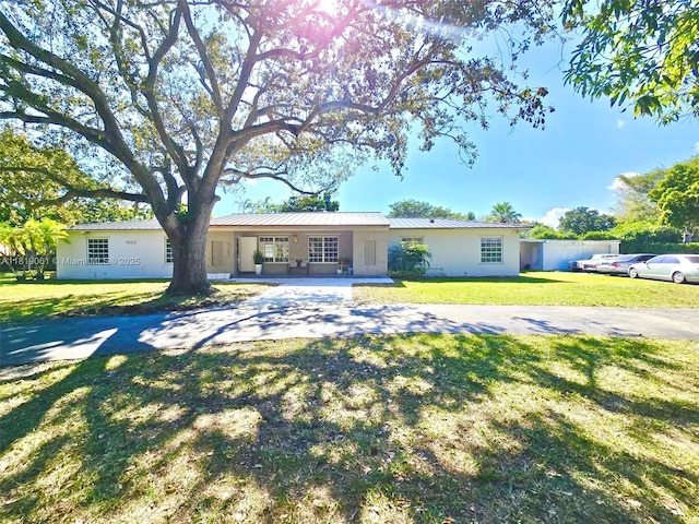7650 SW 78th Ct, Miami, FL 33143 - ranch-style house featuring a front lawn, stucco siding, and a metal roof