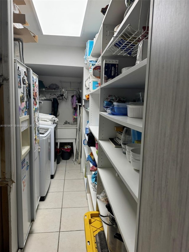 7650 SW 78th Ct, Miami, FL 33143 - washroom with washing machine and clothes dryer, light tile patterned floors, and a skylight