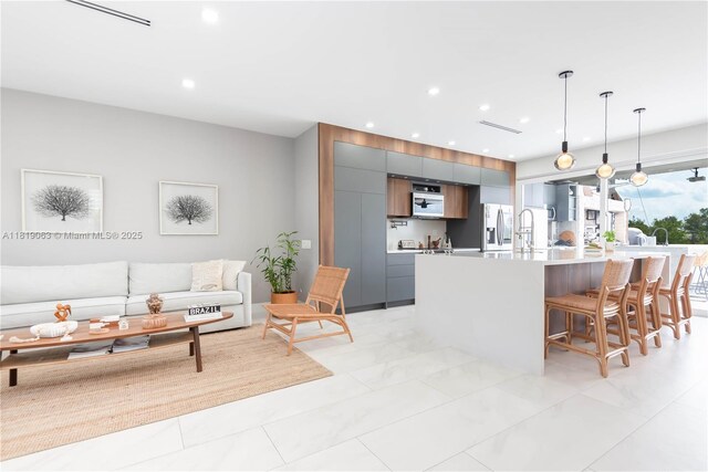 1828 Aspen Ln, Weston, FL 33327 - kitchen featuring modern cabinets, light countertops, a breakfast bar, stainless steel fridge with ice dispenser, and hanging light fixtures