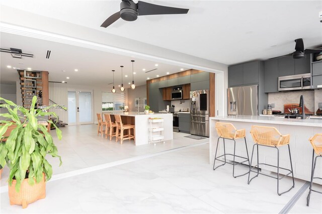 1828 Aspen Ln, Weston, FL 33327 - kitchen with modern cabinets, appliances with stainless steel finishes, a kitchen breakfast bar, light countertops, and gray cabinets