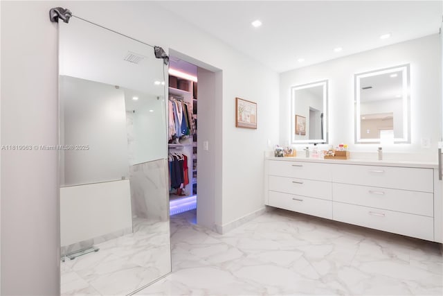 1828 Aspen Ln, Weston, FL 33327 - bathroom featuring double vanity, marble look tiles, recessed lighting, and a walk in closet