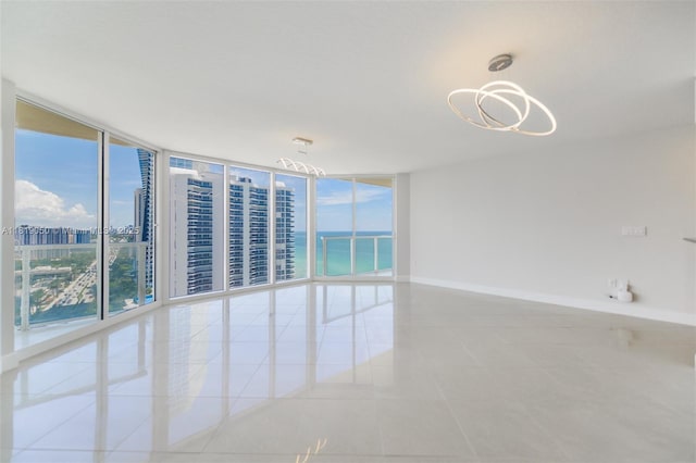 16699 Collins Ave Unit 2107, Sunny Isles Beach, FL 33160 - empty room featuring tile patterned floors, a wall of windows, a chandelier, and a water view