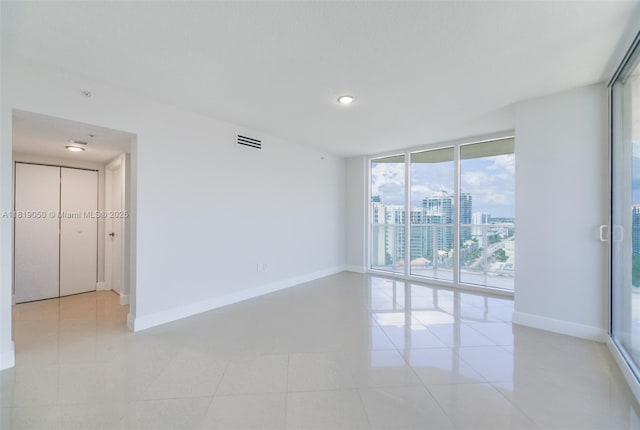 16699 Collins Ave Unit 2107, Sunny Isles Beach, FL 33160 - empty room with floor to ceiling windows, light tile patterned floors, a view of city, and recessed lighting