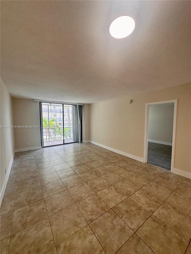 2935 NE 163rd St Unit 3P, North Miami Beach, FL 33160 - unfurnished room with a textured ceiling, light tile patterned floors, and floor to ceiling windows