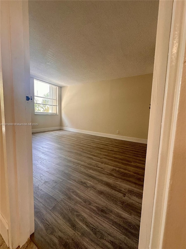 2935 NE 163rd St Unit 3P, North Miami Beach, FL 33160 - spare room with a textured ceiling and dark wood-style floors