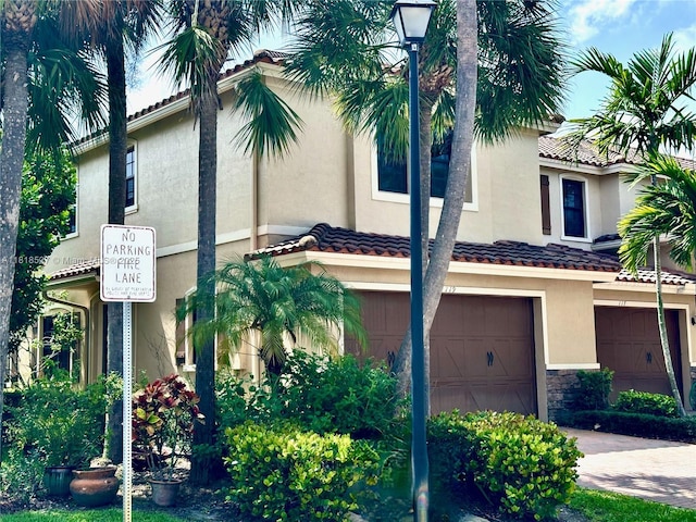 119 Riverwalk Cir E, Plantation, FL 33325 - view of front of house with an attached garage, stucco siding, stone siding, a tiled roof, and driveway