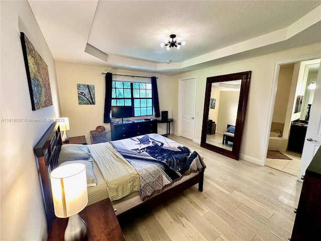 119 Riverwalk Cir E, Plantation, FL 33325 - bedroom with a tray ceiling, light wood-type flooring, a textured ceiling, and ensuite bath