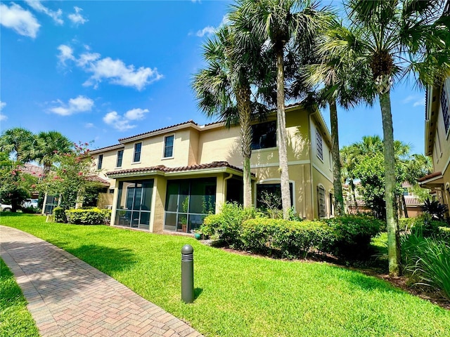 119 Riverwalk Cir E, Plantation, FL 33325 - back of property with stucco siding, a yard, and a sunroom