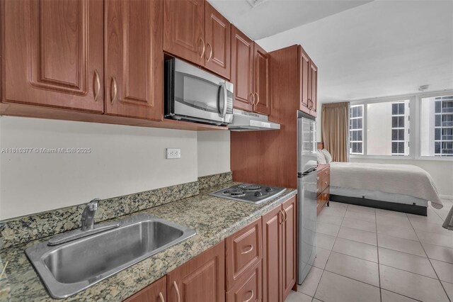 19201 Collins Ave Unit 326, Sunny Isles Beach, FL 33160 - kitchen with stainless steel microwave, a sink, under cabinet range hood, electric cooktop, and brown cabinets