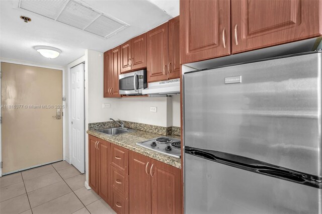 19201 Collins Ave Unit 326, Sunny Isles Beach, FL 33160 - kitchen featuring stainless steel appliances, a sink, under cabinet range hood, light tile patterned floors, and brown cabinets