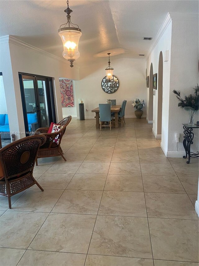 12780 SW 187th St, Miami, FL 33177 - dining room featuring crown molding, a textured ceiling, light tile patterned floors, and arched walkways