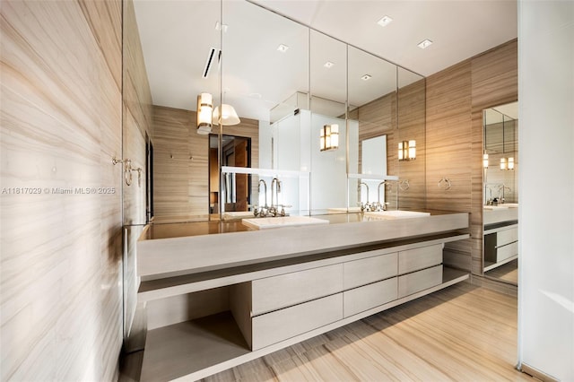 bathroom with double vanity and wood finished floors