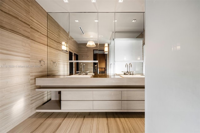 bathroom with double vanity and wood finished floors
