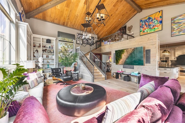 living area with a chandelier, wood finished floors, stairs, a wooden ceiling with exposed beams, and high vaulted ceiling