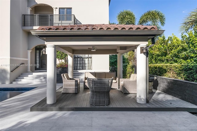 wooden terrace with outdoor lounge area, a ceiling fan, and a gazebo
