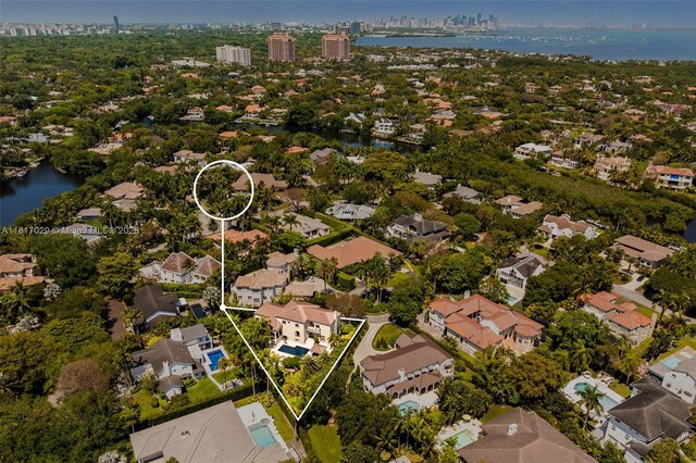 aerial overview of property's location with a nearby body of water, property parcel outlined, and nearby suburban area