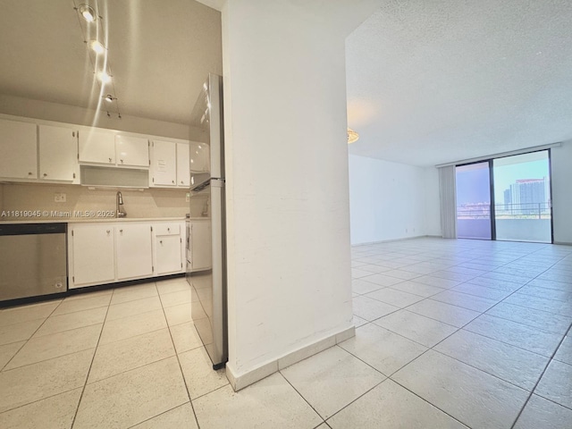 600 Three Islands Blvd Unit 620, Hallandale Beach, FL 33009 - kitchen with dishwasher, light tile patterned flooring, white cabinets, open floor plan, and a wall of windows