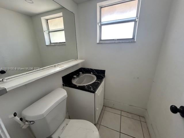 515 SW 3rd St Unit 12, Miami, FL 33130 - half bathroom featuring toilet, vanity, tile patterned flooring, and baseboards