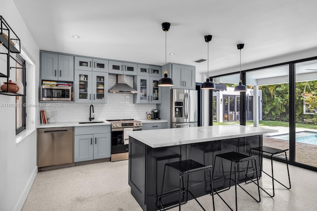 7921 SW 100th St, Miami, FL 33156 - kitchen featuring stainless steel appliances, wall chimney exhaust hood, gray cabinetry, decorative backsplash, and a center island