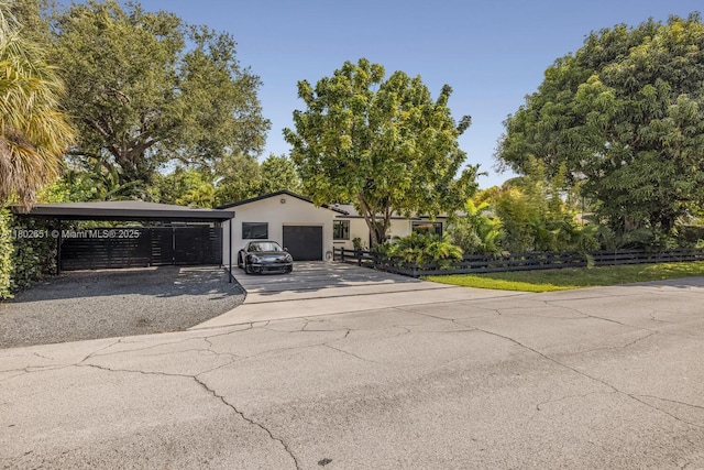 7921 SW 100th St, Miami, FL 33156 - view of front facade featuring driveway, stucco siding, a garage, and view of scattered trees