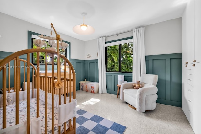 7921 SW 100th St, Miami, FL 33156 - bedroom featuring a decorative wall, a wainscoted wall, speckle patterned floor, and a nursery area