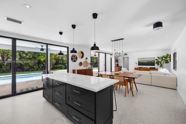 7921 SW 100th St, Miami, FL 33156 - kitchen with dark cabinetry, dark aggregate flooring, a center island, and hanging light fixtures