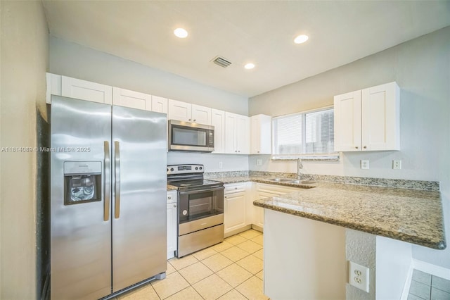 3223 SE 2nd Dr, Homestead, FL 33033 - kitchen featuring stainless steel appliances, a peninsula, white cabinets, light tile patterned floors, and light stone countertops