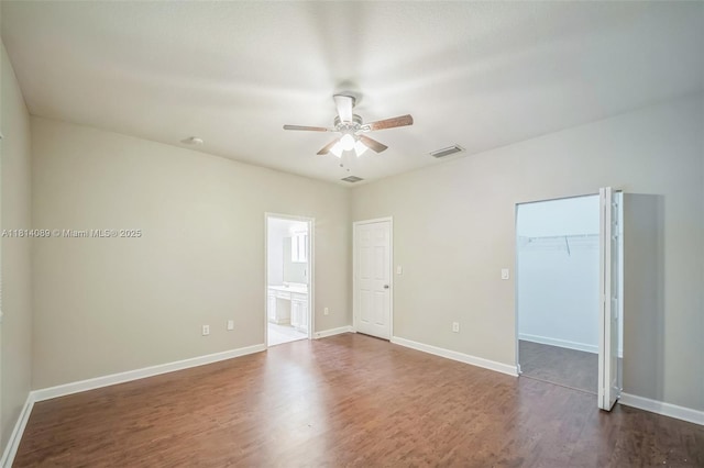 3223 SE 2nd Dr, Homestead, FL 33033 - unfurnished bedroom featuring dark wood-type flooring, connected bathroom, a ceiling fan, a spacious closet, and a closet