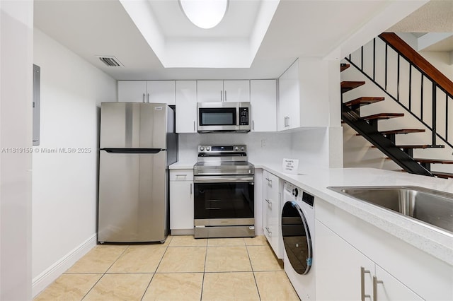 1121 SW 105th Ave Unit 302, Miami, FL 33174 - kitchen with stainless steel appliances, washer / dryer, light countertops, white cabinets, and a raised ceiling