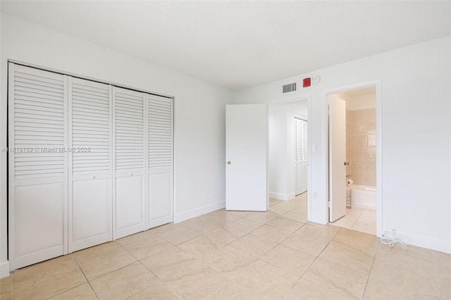 1121 SW 105th Ave Unit 302, Miami, FL 33174 - unfurnished bedroom featuring a closet, light tile patterned floors, baseboards, and connected bathroom