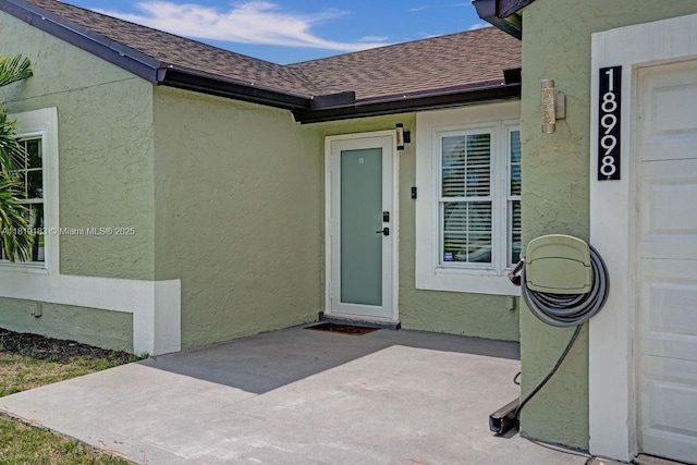 18998 Cloud Lake Cir, Boca Raton, FL 33496 - doorway to property with a shingled roof, a patio area, and stucco siding