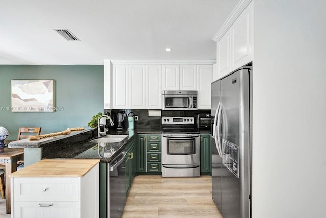 18998 Cloud Lake Cir, Boca Raton, FL 33496 - kitchen with appliances with stainless steel finishes, a peninsula, white cabinets, light wood finished floors, and recessed lighting