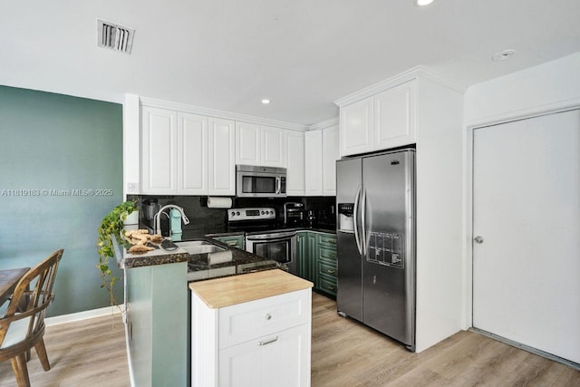 18998 Cloud Lake Cir, Boca Raton, FL 33496 - kitchen with appliances with stainless steel finishes, white cabinets, a peninsula, light wood-style floors, and tasteful backsplash
