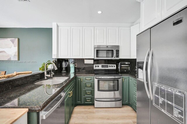 18998 Cloud Lake Cir, Boca Raton, FL 33496 - kitchen featuring appliances with stainless steel finishes, green cabinetry, white cabinetry, dark stone counters, and recessed lighting