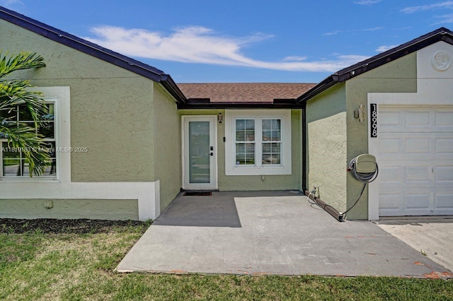 18998 Cloud Lake Cir, Boca Raton, FL 33496 - doorway to property featuring stucco siding, a garage, and roof with shingles
