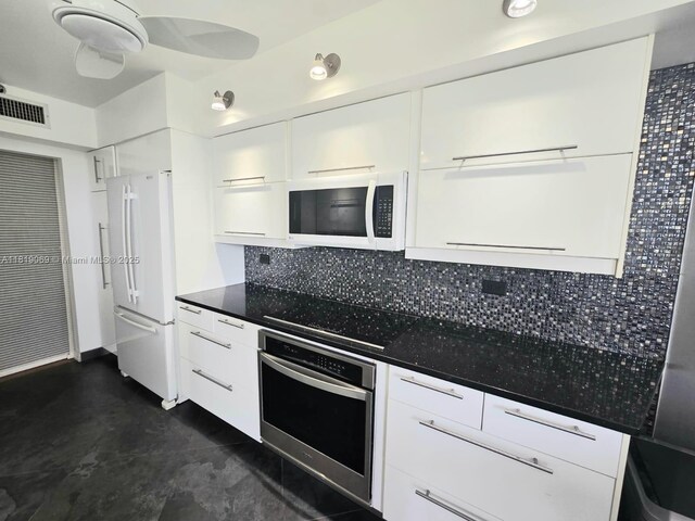 7400 Radice Ct Unit 402, Lauderhill, FL 33319 - kitchen featuring white appliances, white cabinetry, and dark countertops