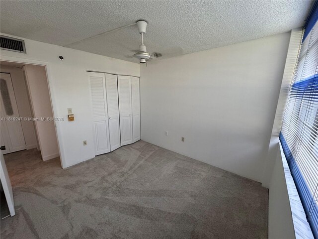 1100 Saint Charles Pl Unit 203, Pembroke Pines, FL 33026 - unfurnished bedroom featuring carpet floors, a closet, a textured ceiling, and ceiling fan