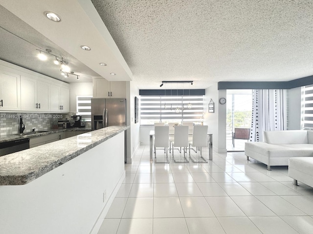 2741 Taft St Unit 410, Hollywood, FL 33020 - kitchen featuring rail lighting, a textured ceiling, decorative backsplash, light stone countertops, and light tile patterned flooring