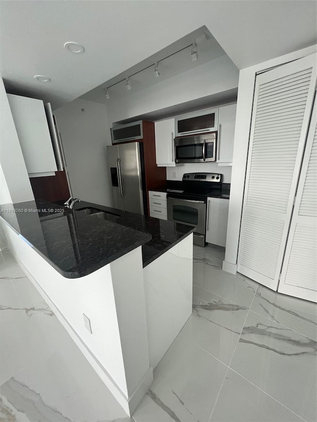 7350 SW 89th St Unit 2011S, Miami, FL 33156 - kitchen featuring stainless steel appliances, light marble finish floors, a sink, white cabinets, and a peninsula