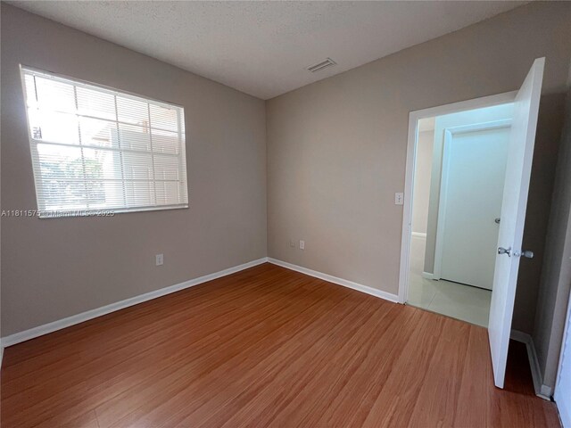 1881 NW 96th Ter Unit 7C, Pembroke Pines, FL 33024 - spare room with light wood-style flooring and a textured ceiling