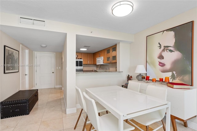 2101 Brickell Ave Unit 2409, Miami, FL 33129 - dining area featuring light tile patterned floors and baseboards