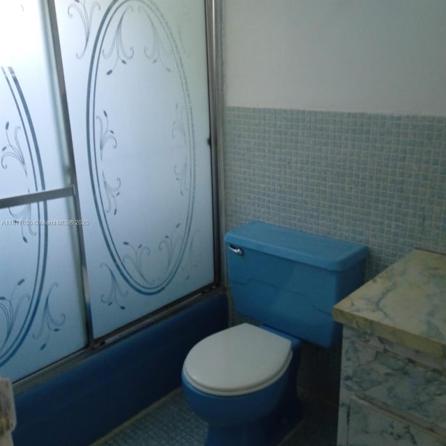 6201 SW 37th St Unit 113, Davie, FL 33314 - bathroom featuring a wainscoted wall, tile walls, and shower / washtub combination