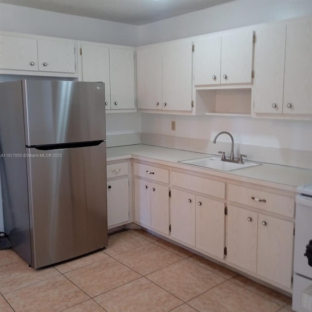 6201 SW 37th St Unit 113, Davie, FL 33314 - kitchen with freestanding refrigerator, light countertops, open shelves, light tile patterned floors, and range