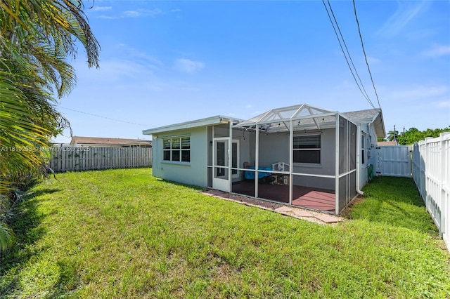 back of house featuring a fenced backyard and glass enclosure