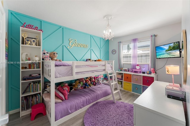 bedroom with wood finished floors and a chandelier