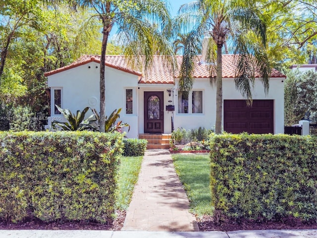 1036 Palermo Ave, Coral Gables, FL 33134 - mediterranean / spanish-style house featuring a tile roof, stucco siding, and a garage